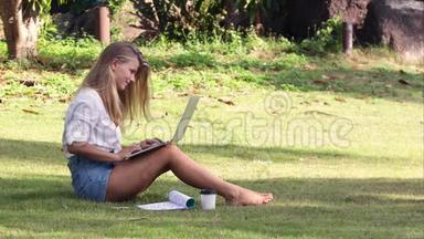 女学生在暑期公园的笔记本上在线学习。
